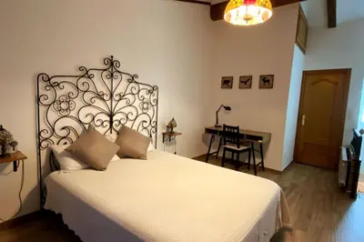 a bedroom with a white bed with a metal headboard at Casa de ensueño a 5 minutos de la playa in Valencia