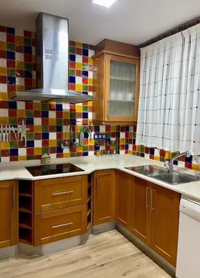 a kitchen with wooden cabinets and a sink and a window at Casa de ensueño a 5 minutos de la playa in Valencia