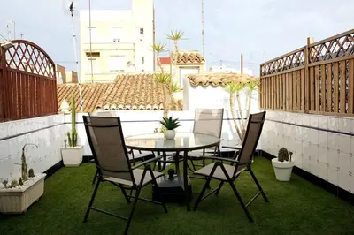 a patio with a table and chairs on a balcony at Casa de ensueño a 5 minutos de la playa in Valencia