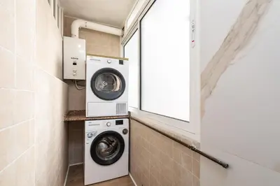 a laundry room with a washer and dryer at UrbanNest Apartment in Valencia