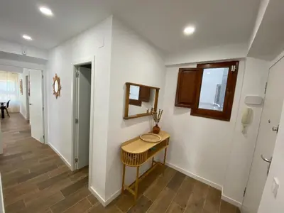 a hallway with a table and a mirror on a wall at 100 metros playa con vistas al mar Piso nuevo 2024 in Cullera