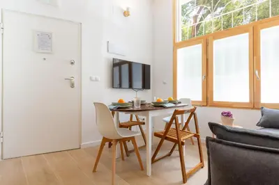 a living room with a table and chairs and a tv at Nuevo loft cerca del centro y Ciudad Artes y Ciencias in Valencia