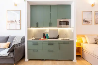 a kitchen with a sink next to a couch at Nuevo loft cerca del centro y Ciudad Artes y Ciencias in Valencia