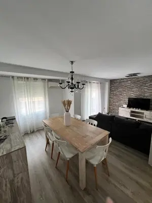 a dining room with a table and a couch at Departamento en Torrent in Torrent