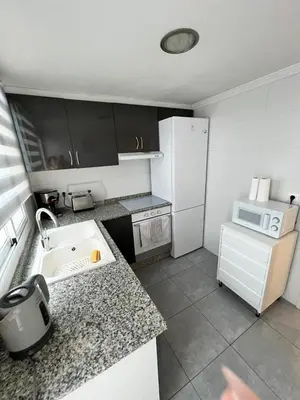 a kitchen with a sink and a white refrigerator at Departamento en Torrent in Torrent