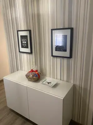 a white dresser with two pictures on a wall at Departamento en Torrent in Torrent