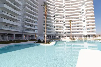 a swimming pool in front of a large apartment building at Gran Canet Vlado in Canet de Berenguer