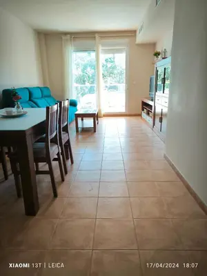 a living room with a table and a blue couch at Apartamento Masia Racó Cullera in Cullera