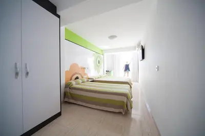 a bedroom with two beds and a person standing in the window at Sol Playa in Valencia
