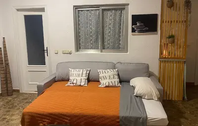 a living room with a couch with pillows on it at Acogedora planta baja in Benaguacil