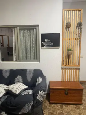 a living room with a couch and a mirror at Acogedora planta baja in Benaguacil