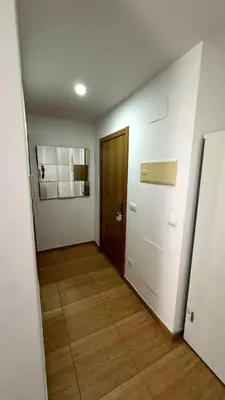 a hallway with a door and a wooden floor at Apartamentos Felip 3 in Burriana