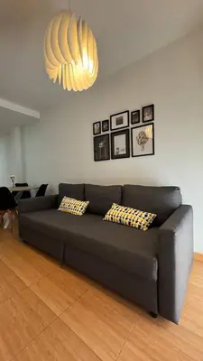 a black couch in a living room with a chandelier at Apartamentos Felip 3 in Burriana