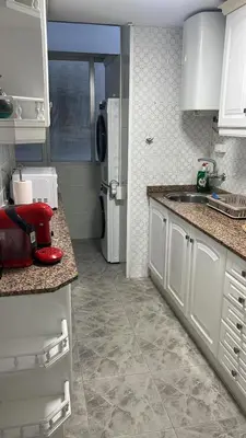 a kitchen with white cabinets and a white refrigerator at Apartments del sol in Cullera