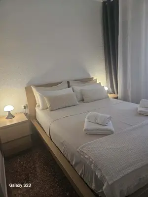 a bedroom with a bed with white sheets and pillows at Apartments del sol in Cullera