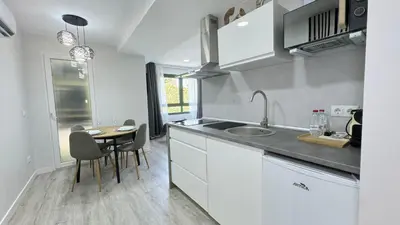a kitchen with a sink and a table with chairs at Versus Apartments near City of Arts III in Valencia