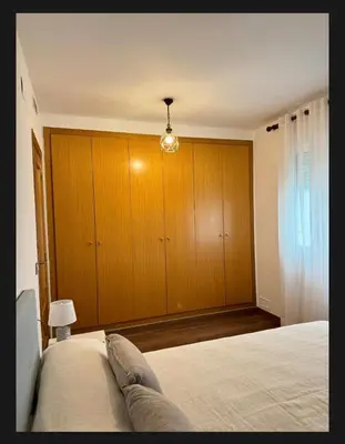 a bedroom with a bed and wooden cabinets at Casa Emma in Burriana