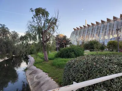 a river with a building in the background next to a building at Turia Gardens Rooms - Authentic Valencia Downtown Parklife - VLC Urban Rental in Valencia