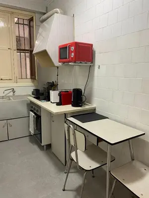 a small kitchen with a table and a red microwave at Turia Gardens Rooms - Authentic Valencia Downtown Parklife - VLC Urban Rental in Valencia