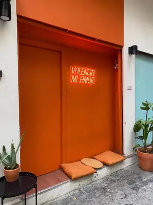 an orange door of a building with a sign on it at Turia Gardens Rooms - Authentic Valencia Downtown Parklife - VLC Urban Rental in Valencia