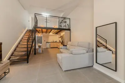 a living room with a white couch and a mirror at La Suite Mediterránea - Housevanlive in Valencia