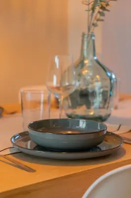 a bowl on a table with two glasses and a vase at La Suite Mediterránea - Housevanlive in Valencia