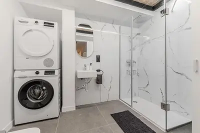 a bathroom with a washing machine and a sink at La Suite Mediterránea - Housevanlive in Valencia