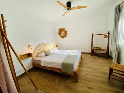 a bedroom with a bed and a ceiling fan at El Riuet-Chalet apartamento a 1 minuto de la playa, Cullera in Cullera