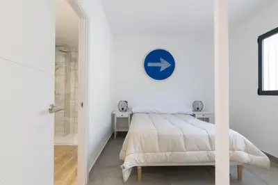 a bedroom with a bed and a blue clock on the wall at NEW BEACH Flats valencia 1 in Valencia