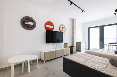 a living room with a couch and a tv on a wall at NEW Beach Flats Valencia 3 in Valencia