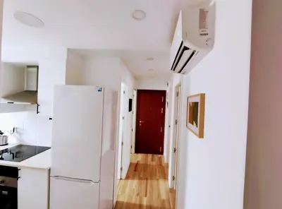 a kitchen with a white refrigerator and a red door at Apartamento 3 Habitaciones 2 Baños in Puerto de Sagunto