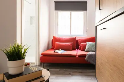 a red couch in a living room with a window at SingularStays Padre Urbano in Valencia