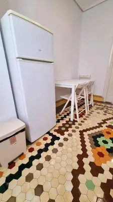 a kitchen with a white refrigerator and a table at Habitación Maritim 2 in Valencia
