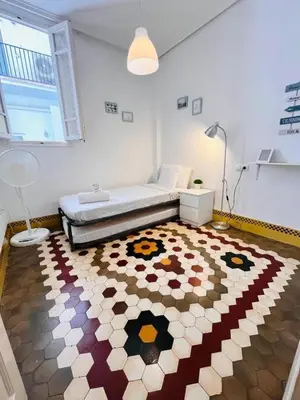 a bedroom with a bed and a rug on the floor at Habitación Maritim 2 in Valencia