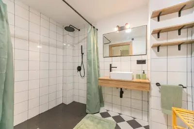 a bathroom with a shower with a sink and a mirror at Cozy loft Jubeco in Valencia