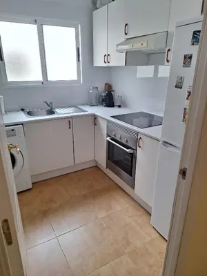 a kitchen with white cabinets and a sink and a stove at Cozy Appartement - Lumineux 3 pièces, à côté du Jardin de Turia in Valencia