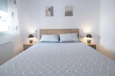 a large white bed in a bedroom with two lamps at Piso Reformado Cerca de la Playa y de Valencia Ciudad en el Barrio de San Antonio in Cullera