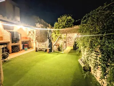 a backyard with a green lawn at night at Casa Fina in Anna