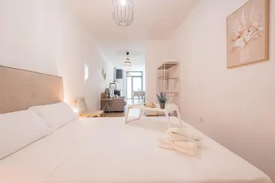 a white bedroom with a white bed with towels on it at VisitVal Flats 1 in Valencia