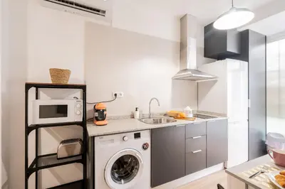 a kitchen with a washing machine and a microwave at VisitVal Flats 2 in Valencia