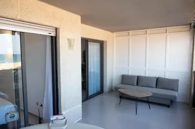 a living room with a couch and a table at Espacio2,1a línea,jacuzzi,piscina in Cullera
