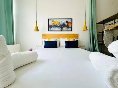 a large white bed in a room with two chairs at New Industrial Design Flat in Russafa SOHO in Valencia