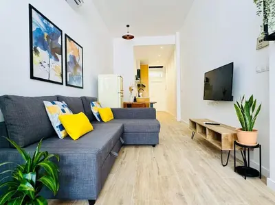 a living room with a blue couch and yellow pillows at New Industrial Design Flat in Russafa SOHO in Valencia