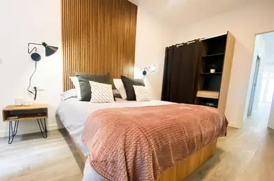 a bedroom with a large bed with a wooden headboard at Apartamento Ciencias & Maritim in Valencia