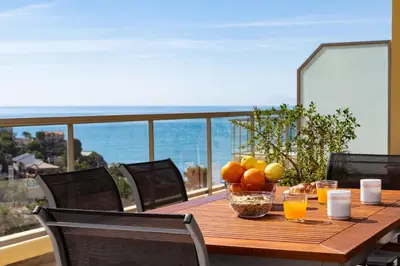 a wooden table with a bowl of fruit on a balcony at Sea View Terrace Apartment Cullera in Cullera
