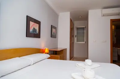 a bedroom with a white bed and a table at Sea View Terrace Apartment Cullera in Cullera