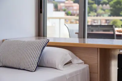 a pillow sitting on a bed next to a table at Sea View Terrace Apartment Cullera in Cullera
