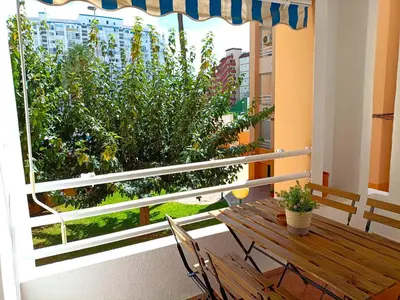 a balcony with a wooden table and chairs and a window at Premium Beach Flat in Las Canteras