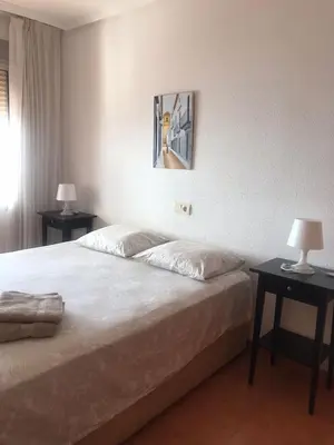 a bedroom with a bed with two tables and two lamps at Aloha frente al Mar in Cullera