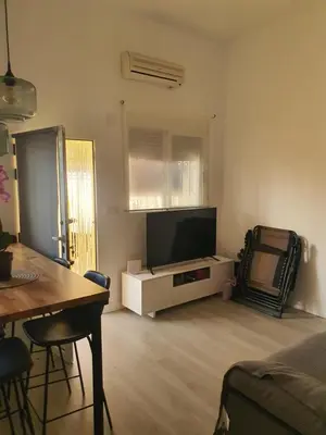 a living room with a flat screen tv and a table at Loft Canet in Canet de Berenguer